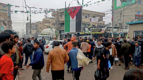 Палестинцы, в том числе многие перемещенные лица из других районов сектора Газа, идут по главной площади в Рафахе  - Sputnik Кыргызстан