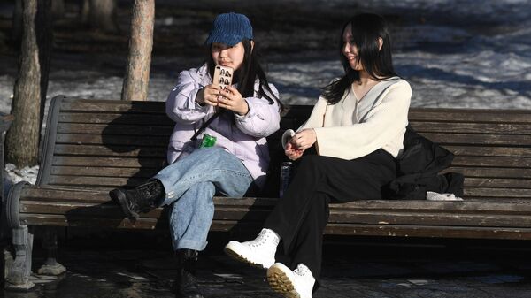 Девушки сидят на скамейке в парке в теплую погоду. Архивное фото - Sputnik Кыргызстан
