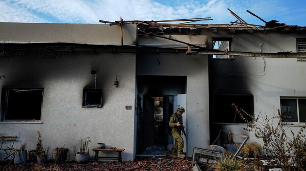 Израильский солдат осматривает дом, поврежденный боевиками Хамаса в кибуце Беэри в Израиле - Sputnik Кыргызстан