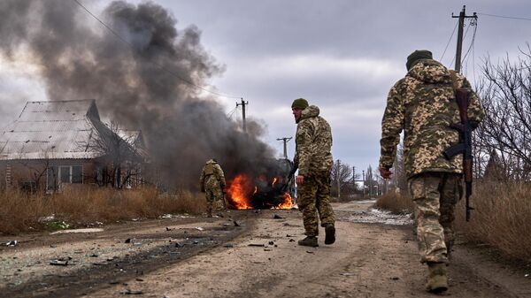 Украинские солдаты проходят мимо горящего автобуса недалеко от Артемовска - Sputnik Кыргызстан