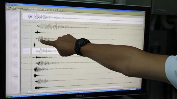 Сейсмолог указывает на сейсмограф, показывающий баллы землетрясения. Архивное фото  - Sputnik Кыргызстан