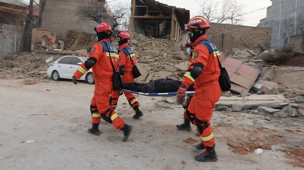 Спасатели несут пострадавшего после землетрясения в на северо-западе Китая. Архивное фото - Sputnik Кыргызстан