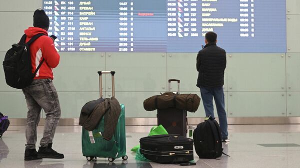 Пассажиры возле электронного табло в аэропорту. Архивное фото - Sputnik Кыргызстан