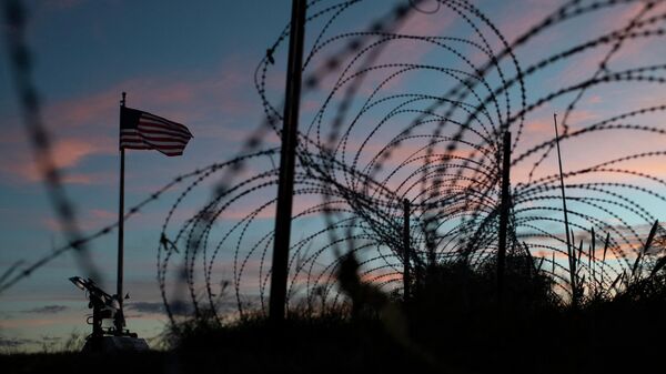 Американский флаг развевается над забором из колючей проволоки рядом с рекой Рио-Гранде в штате Техас - Sputnik Кыргызстан