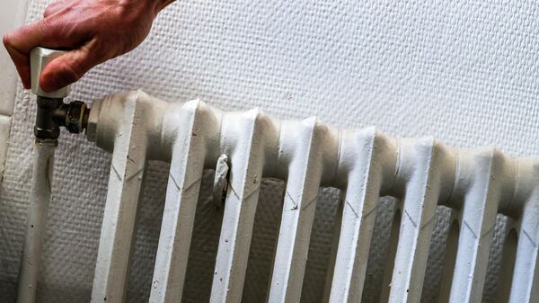 Мужчина регулирует термостат радиатора. Архивное фото  - Sputnik Кыргызстан