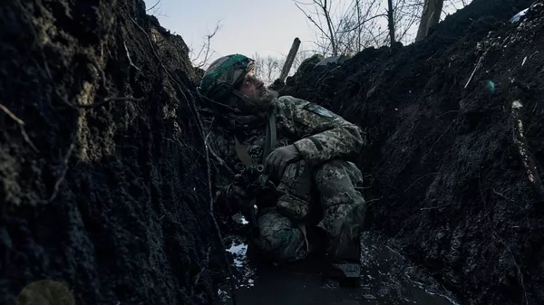 Украинский военнослужащий сидит в окопе. Архивное фото  - Sputnik Кыргызстан
