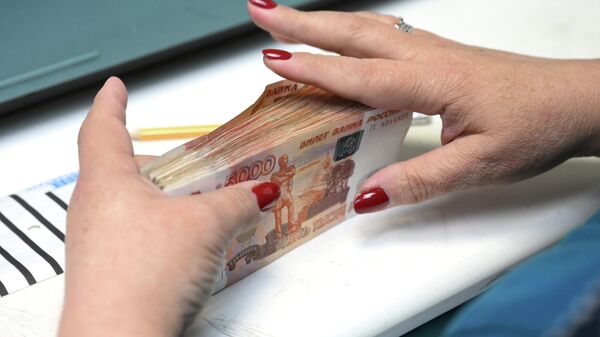 Сотрудница банка пересчитывает купюры номиналом в пять тысяч рублей. Архивное фото - Sputnik Кыргызстан