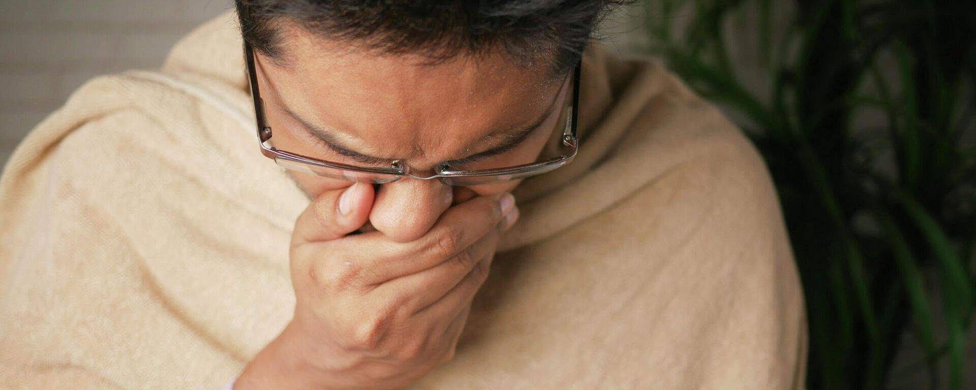 Человек прикрывает рот ладонью во время кашля. Иллюстративное фото  - Sputnik Кыргызстан, 1920, 16.10.2025