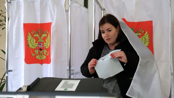 Женщина голосует на выборах президента России на избирательном участке в Севастополе. - Sputnik Кыргызстан