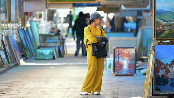 Девушка смотрит картины в уличной галерее на проспекте Чуй в Бишкеке - Sputnik Кыргызстан