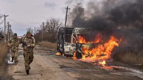 Украиналык аскерлер Артемовскинин айланасында күйүп жаткан микроавтобустун жанынан өтүп баратышат. Архив - Sputnik Кыргызстан
