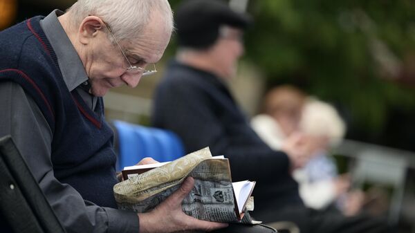 Пожилой мужчина во время чтения книги в парке. Архивное фото  - Sputnik Кыргызстан