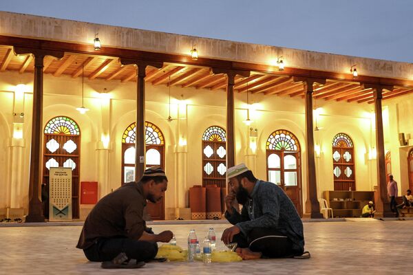 Мужчины прерывают пост в последний день священного для мусульман месяца Рамадан возле мечети на базаре Сук Вакиф в Дохе, Катар  - Sputnik Кыргызстан