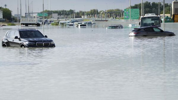 Брошенные автомобили стоят в паводковой воде, покрывающей главную дорогу в Дубае, ОАЭ - Sputnik Кыргызстан