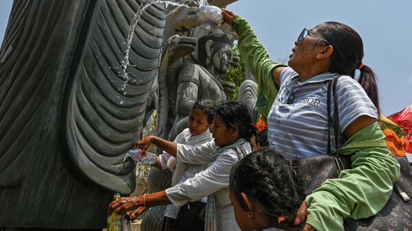 Люди поливают водой статуи Будды во время празднования Сонгкрана в Камбодже - Sputnik Кыргызстан