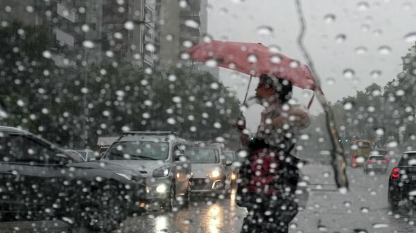 Пешеход с зонтом переходит улицу во время дождя. Архивное фото - Sputnik Кыргызстан