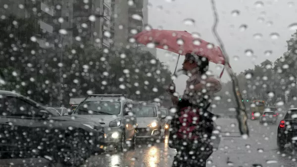 Пешеход с зонтом переходит улицу во время дождя. Архивное фото - Sputnik Кыргызстан