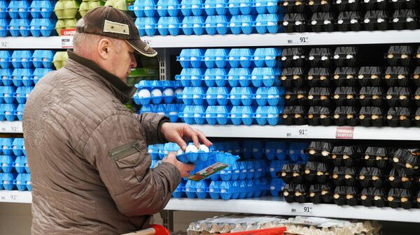 Покупатель выбирает куриные яйца в супермаркете. Архивное фото - Sputnik Кыргызстан