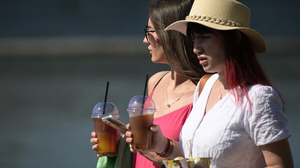 Девушки с прохладительными напитками гуляют по  городу в жаркую погоду. Архивное фото  - Sputnik Кыргызстан