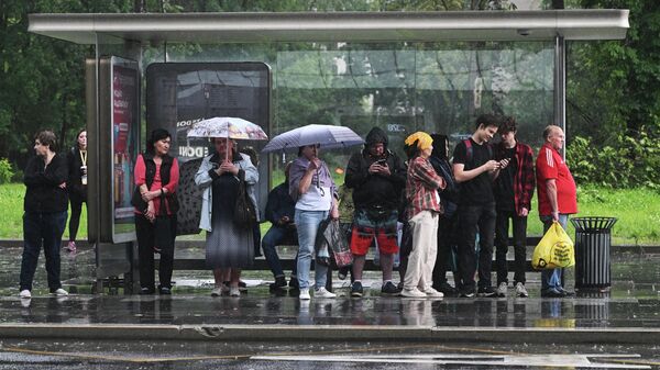 Люди стоят на остановке во время дождя. Архивное фото  - Sputnik Кыргызстан