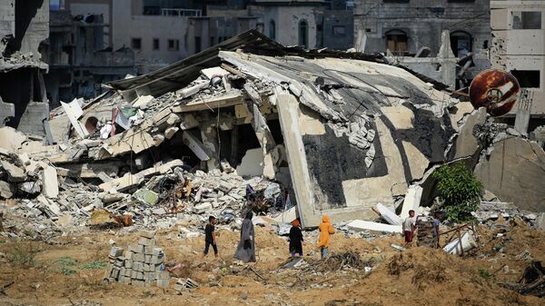 Палестинцы у разрушенных зданий на юге сектора Газа - Sputnik Кыргызстан