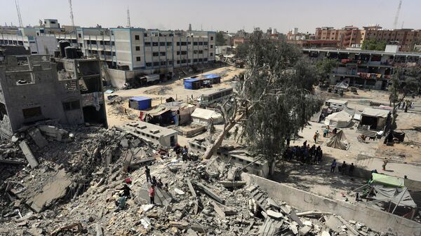 Палестинцы проверяют разрушения после израильского удара по пятиэтажному зданию в Хан-Юнисе на юге сектора Газа - Sputnik Кыргызстан