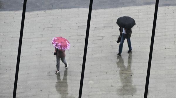 Люди с зонтами в отражении окон здания во время дождя. Архивное фото - Sputnik Кыргызстан