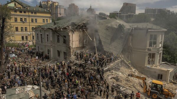 Люди разбирают завалы разрушенного здания детской больницы в Киеве - Sputnik Кыргызстан
