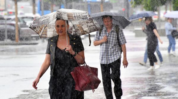 Люди с зонтами идут по улице во время сильного дождя. Архивное фото  - Sputnik Кыргызстан