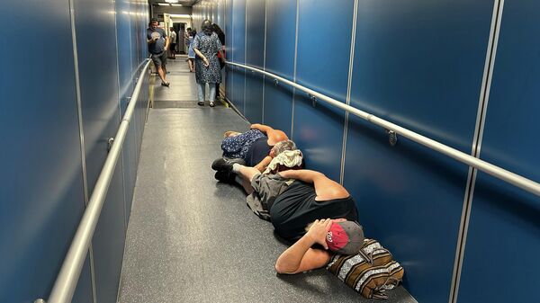 Люди в аэропорту Лос-Анджелеса спят в трапе самолета, из-за глобального технического сбоя - Sputnik Кыргызстан