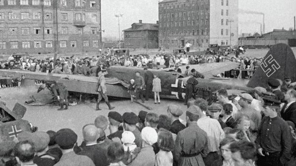 Шаардыктар Москвадагы салгылашууда кулап түшкөн немис учагын көрүп жатышат. Архив - Sputnik Кыргызстан