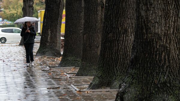 Девушка идет по бульвару Эркиндик во время дождя в Бишкеке. Архивное фото - Sputnik Кыргызстан