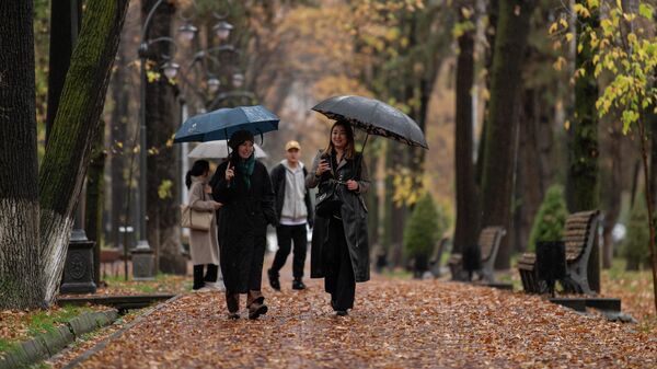 Девушки с зонтами идут по бульвару Эркиндик в Бишкеке во время дождя.  Архивное фото  - Sputnik Кыргызстан