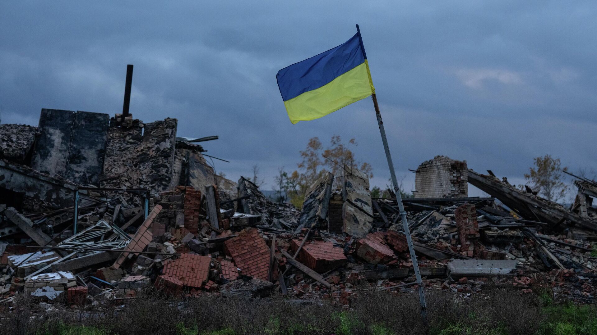 Украинанын желеги Харьков облусундагы имараттардын урандыларынын үстүндө желбиреп турат. Архив - Sputnik Кыргызстан, 1920, 01.01.2025