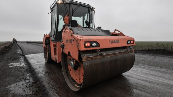 Рабочий управляет асфальтоукладчиком во время ремонта дорожного полотна. Архивное фото - Sputnik Кыргызстан