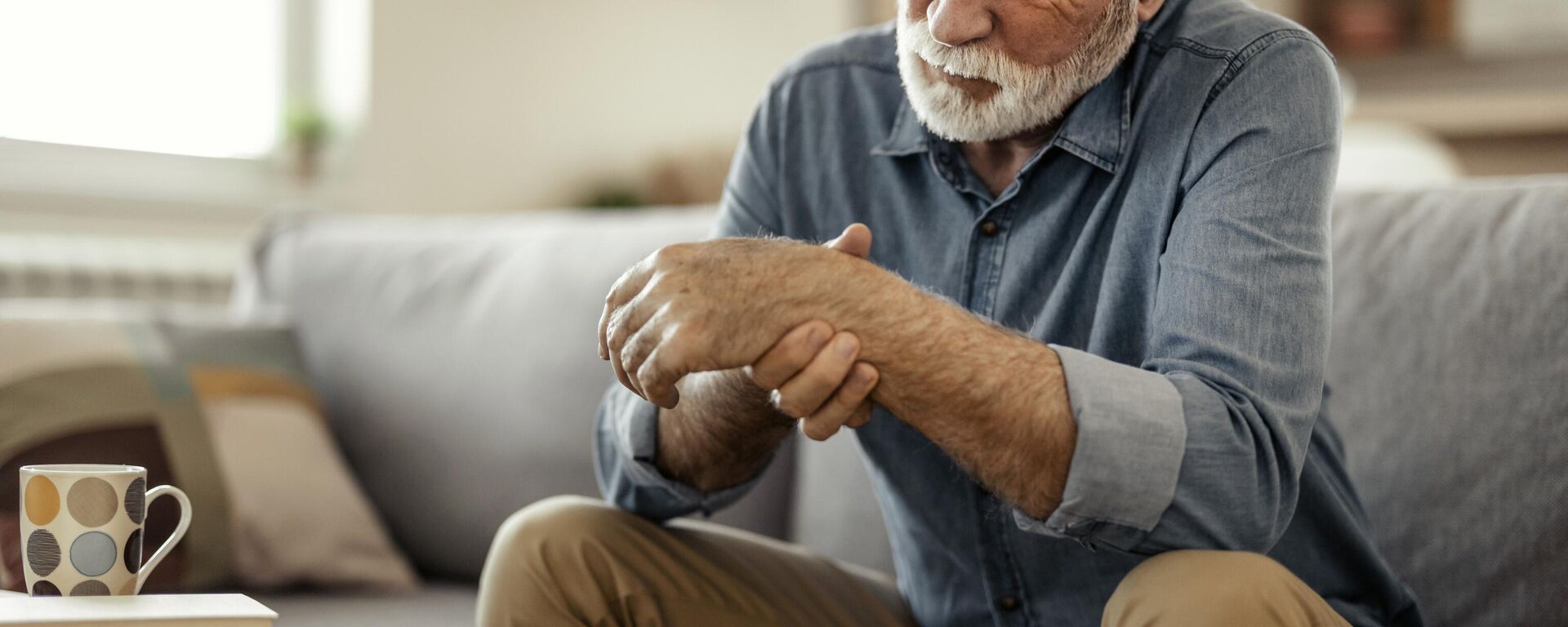 Ревматизмден ооруган улгайган адам колун укалап жатат. Иллюстративдик сүрөт - Sputnik Кыргызстан, 1920, 06.07.2025