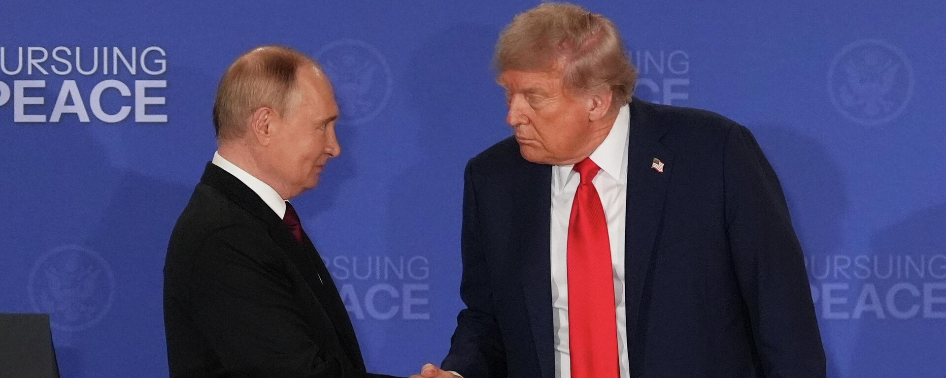 Президент США Дональд Трамп жмет руку президенту России Владимиру Путину во время встречи на Аляске - Sputnik Кыргызстан, 1920, 19.08.2025