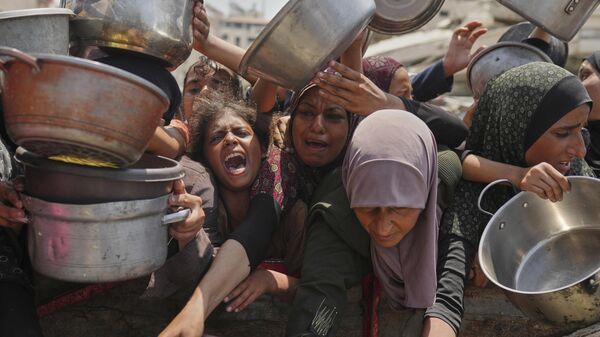 Палестинцы с трудом получают пожертвованную еду на общественной кухне в городе Газа - Sputnik Кыргызстан
