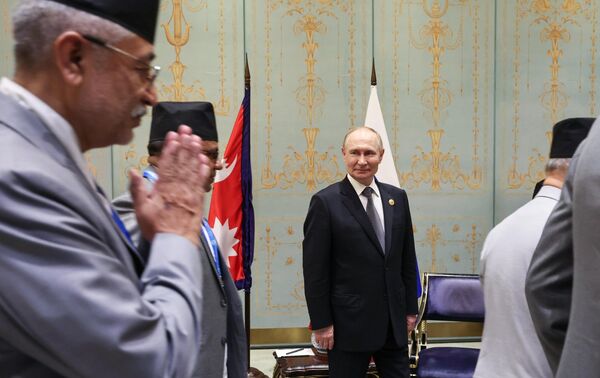 Саммит собрал рекордное число лидеров государств —  более 30 президентов и премьер-министров из Европы и Азии участвовали во встрече в Тяньцзине. На фото: президент РФ Владимир Путин и члены делегации Непала во время встречи на полях саммита. - Sputnik Кыргызстан