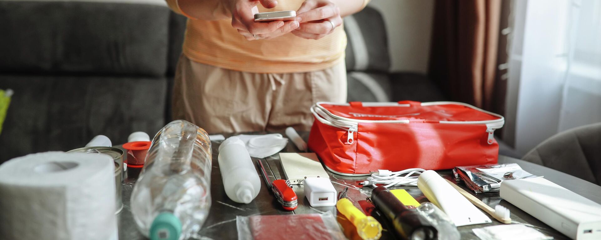 Девушка проверяет содержимое тревожного чемодана. Иллюстративное фото - Sputnik Кыргызстан, 1920, 12.09.2025