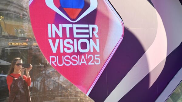 Москвадагы Интервидение 2025 музыка сынагынын баннеринин жанындагы келин - Sputnik Кыргызстан