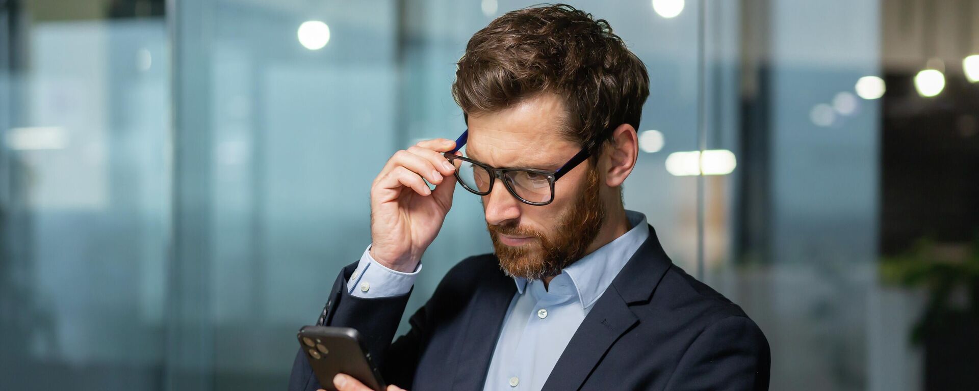 Мужчина со смартфоном в офисе. Иллюстративное фото - Sputnik Кыргызстан, 1920, 22.09.2025