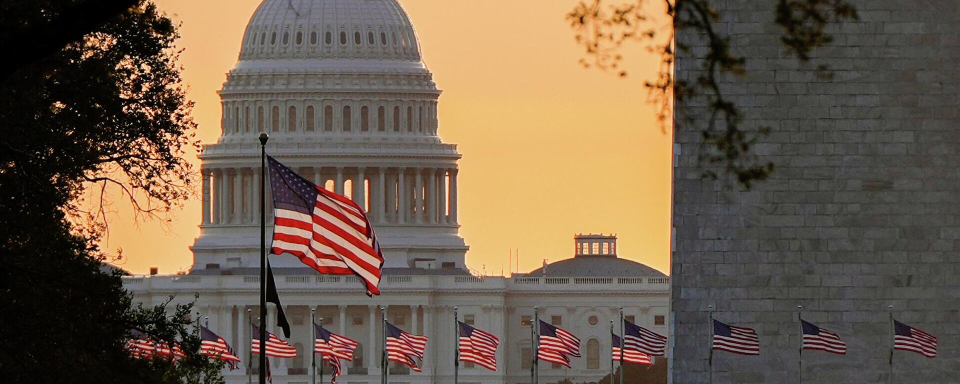 Американские флаги развеваются перед зданием Капитолия в Вашингтоне - Sputnik Кыргызстан, 1920, 02.10.2025