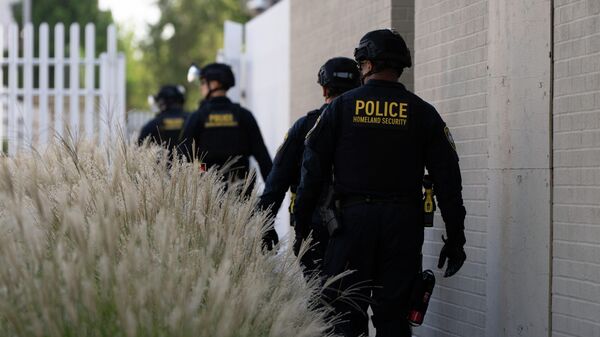 Сотрудники Министерства внутренней безопасности идут к воротам здания иммиграционной и таможенной службы США в Портленде - Sputnik Кыргызстан