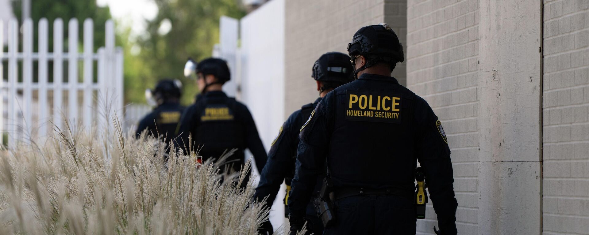 Сотрудники Министерства внутренней безопасности идут к воротам здания иммиграционной и таможенной службы США в Портленде - Sputnik Кыргызстан, 1920, 02.10.2025