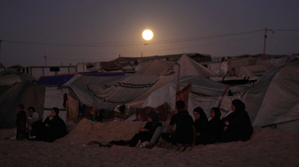 Луна восходит над палаточным лагерем для перемещенных палестинцев в Хан-Юнисе на юге сектора Газа - Sputnik Кыргызстан