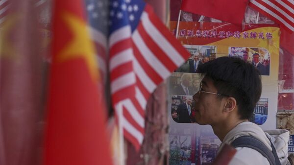 Мужчина заходит в магазин где висят флаги Китая и США в Пекине. Архивное фото - Sputnik Кыргызстан