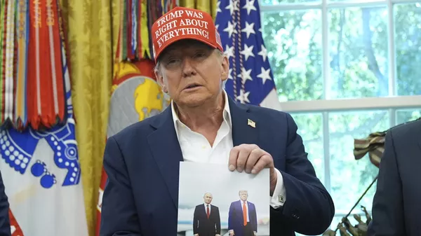 Президент США Дональд Трамп держит фотографию с президентом России Владимиром Путиным. Архивное фото - Sputnik Кыргызстан