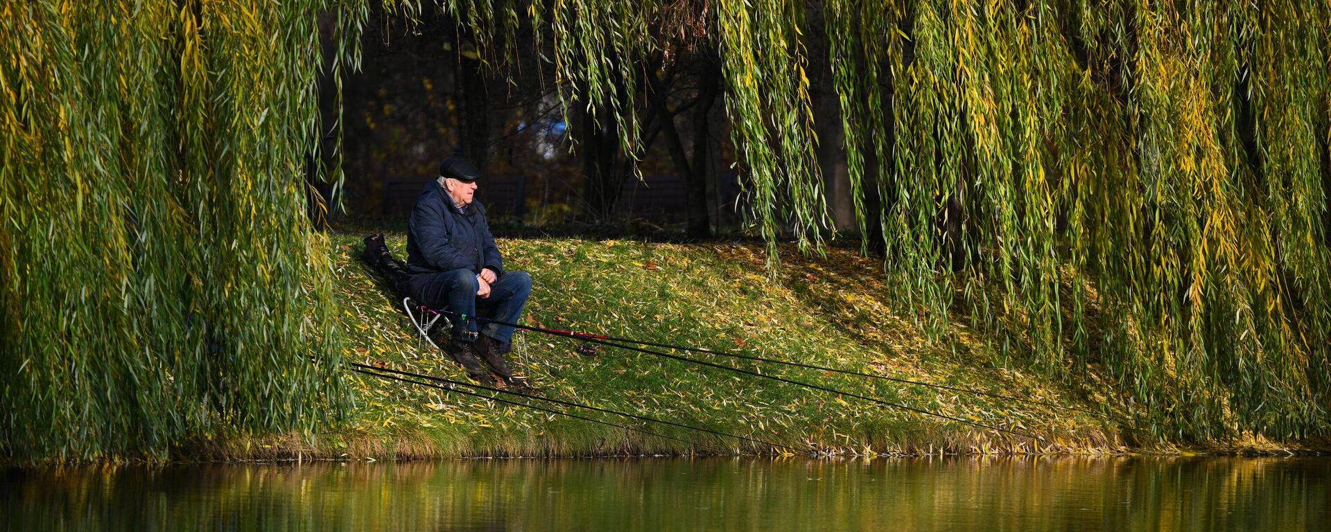 Мужчина ловит рыбу на берегу пруда - Sputnik Кыргызстан, 1920, 12.11.2025