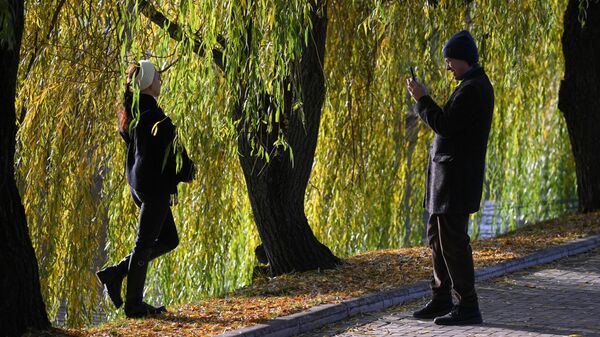 Мужчина фотографирует девушку на берегу пруда. Архивное фото - Sputnik Кыргызстан